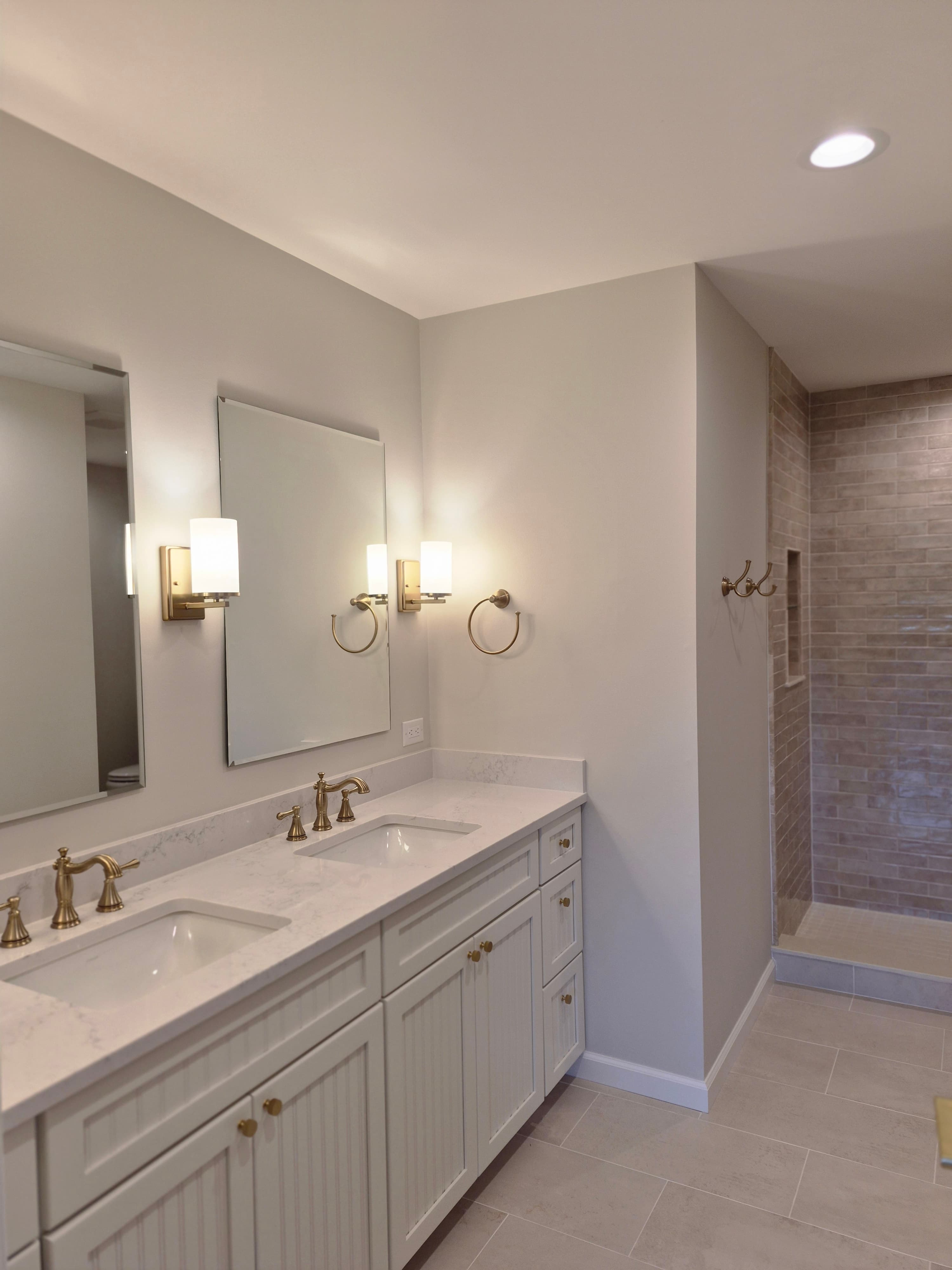 A double vanity with brass fixtures, wiped and polished