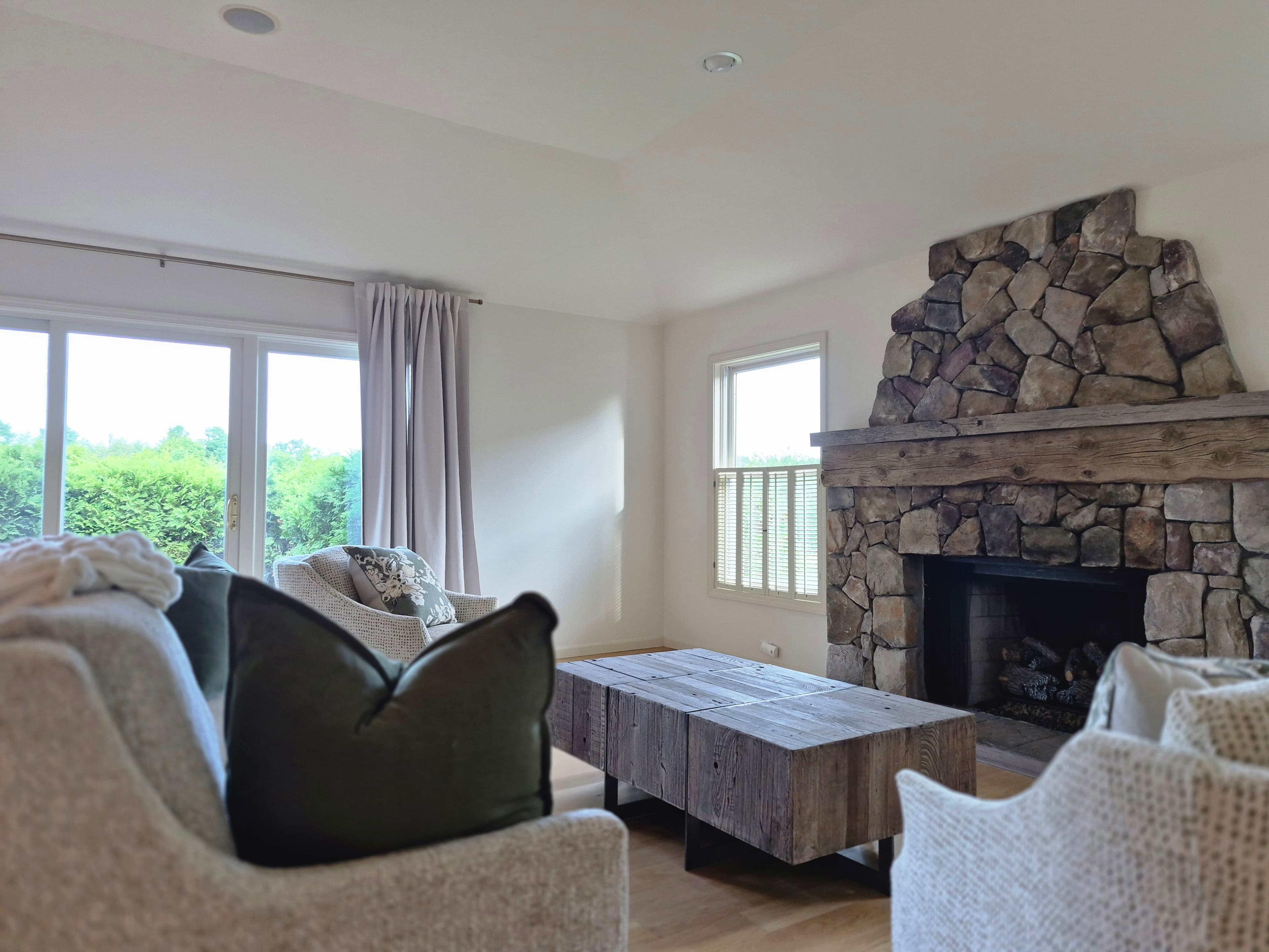 A living room with a stone fireplace, freshly cleaned by A+W