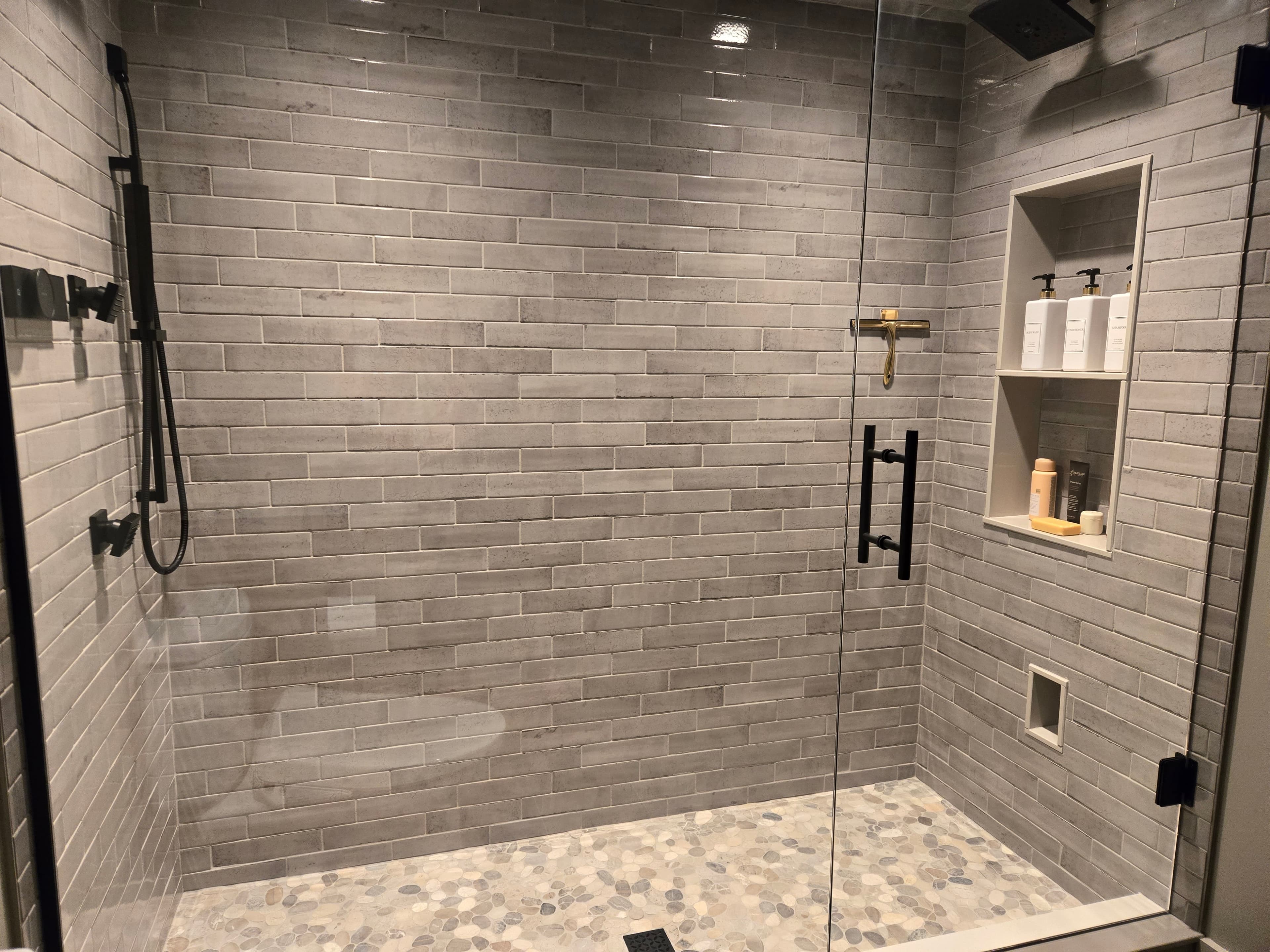 A tiled walk-in shower with clean glass and fixtures